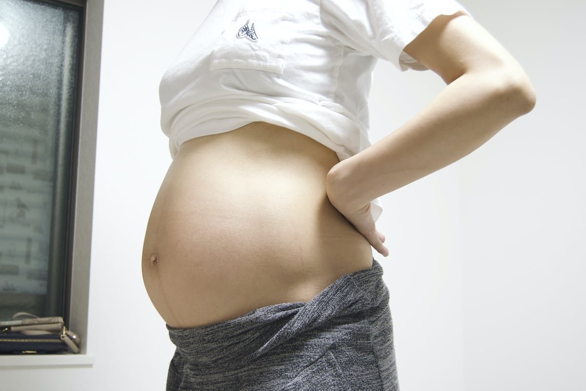 妊娠38週でお腹を出した立ち姿の妊婦様のお写真